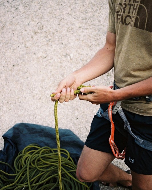 Outdoor rock climber ascending mountain cliff in scenic landscape