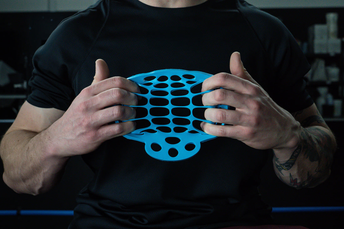 Athlete using Fingoflex hand exerciser during warm-up at the gym